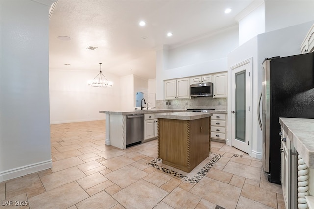 4014 Trapani Pl, Las Vegas, NV 89141 - kitchen with stainless steel appliances, a peninsula, a chandelier, backsplash, and a center island
