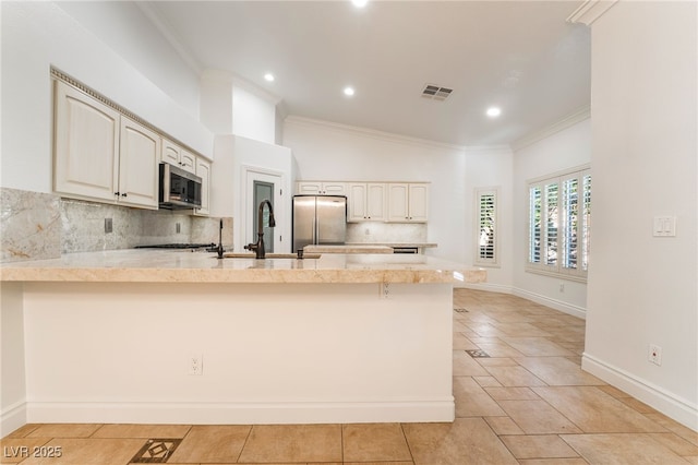4014 Trapani Pl, Las Vegas, NV 89141 - kitchen featuring appliances with stainless steel finishes, a peninsula, ornamental molding, decorative backsplash, and recessed lighting