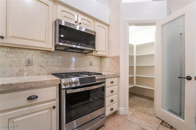 4014 Trapani Pl, Las Vegas, NV 89141 - kitchen with appliances with stainless steel finishes, light countertops, backsplash, and cream cabinets