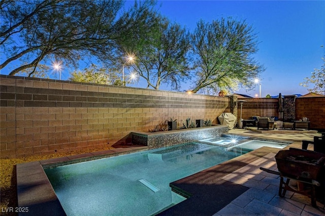 6897 Linda Creek Ct, Las Vegas, NV 89178 - pool at dusk with an in-ground hot tub, a fenced backyard, and a patio area