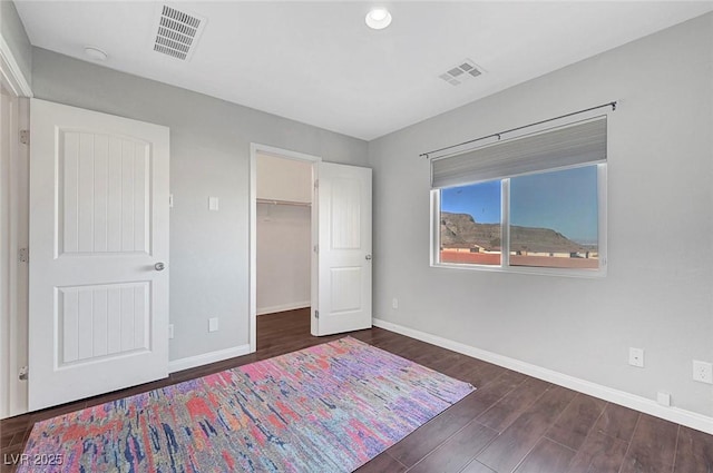 3908 Total Eclipse St, Las Vegas, NV 89129 - unfurnished bedroom featuring dark wood-style flooring, a spacious closet, recessed lighting, and a closet