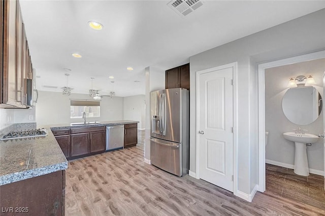 3908 Total Eclipse St, Las Vegas, NV 89129 - kitchen with appliances with stainless steel finishes, light wood-type flooring, dark brown cabinetry, recessed lighting, and a peninsula