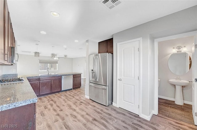 3908 Total Eclipse St, Las Vegas, NV 89129 - kitchen with stainless steel appliances, light wood-style floors, a peninsula, recessed lighting, and ceiling fan
