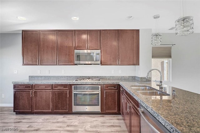 3908 Total Eclipse St, Las Vegas, NV 89129 - kitchen with stainless steel appliances, dark stone countertops, light wood finished floors, recessed lighting, and pendant lighting