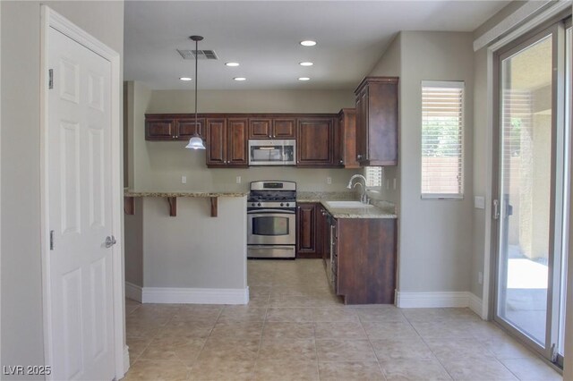 72 Broken Putter Way, Las Vegas, NV 89148 - kitchen featuring appliances with stainless steel finishes, light stone counters, pendant lighting, light tile patterned flooring, and recessed lighting