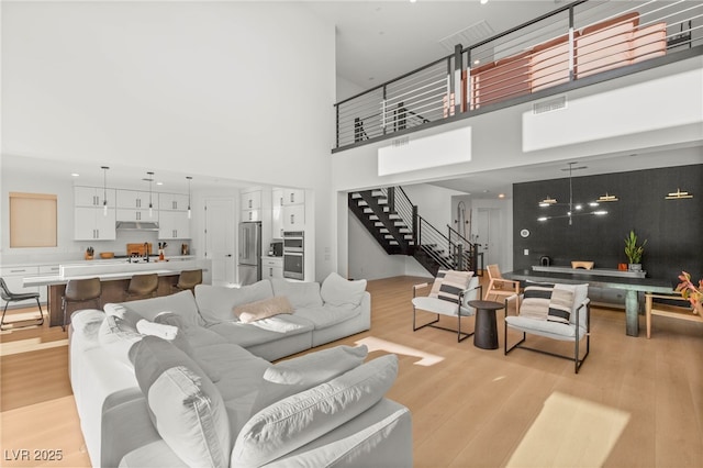 389 Red Feather Peak Ct, Las Vegas, NV 89138 - living area featuring light wood-type flooring, stairs, and a high ceiling