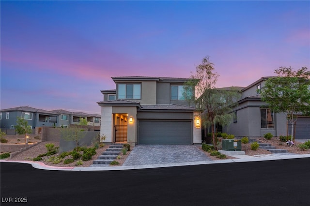389 Red Feather Peak Ct, Las Vegas, NV 89138 - view of front of property featuring stucco siding, an attached garage, and decorative driveway