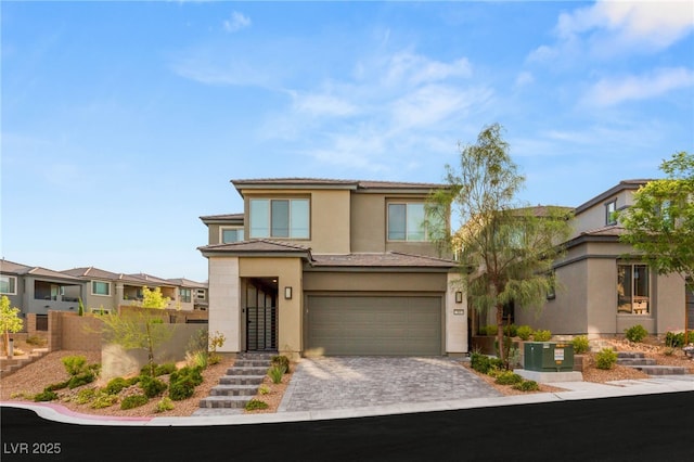 389 Red Feather Peak Ct, Las Vegas, NV 89138 - prairie-style home featuring an attached garage, stucco siding, a residential view, and decorative driveway