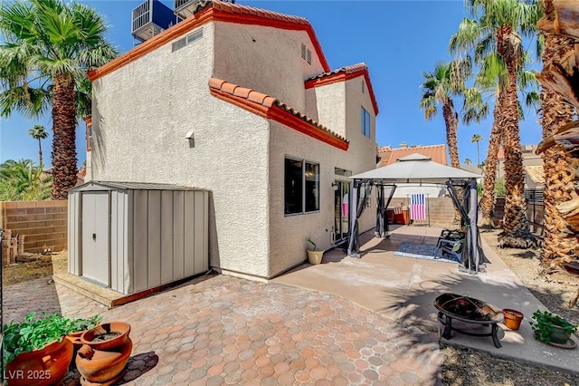 6652 Coral Springs Cir, Las Vegas, NV 89108 - back of property featuring a patio, stucco siding, a gazebo, a shed, and a tile roof
