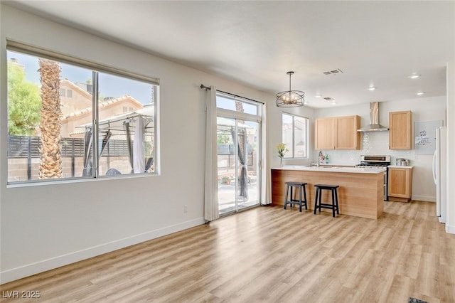 6652 Coral Springs Cir, Las Vegas, NV 89108 - kitchen with wall chimney range hood, stainless steel range oven, a chandelier, plenty of natural light, and recessed lighting