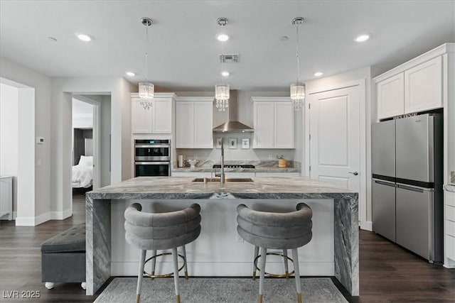 64 Lake Oasis St, Henderson, NV 89011 - kitchen with stainless steel appliances, wall chimney range hood, white cabinets, and recessed lighting