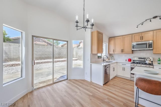 6456 First View Ave, Las Vegas, NV 89142 - kitchen featuring appliances with stainless steel finishes, a chandelier, light countertops, light wood-style flooring, and lofted ceiling