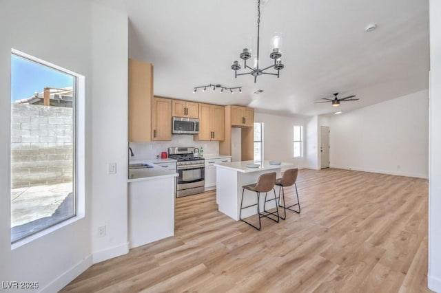 6456 First View Ave, Las Vegas, NV 89142 - kitchen featuring stainless steel appliances, a chandelier, light countertops, ceiling fan, and a breakfast bar