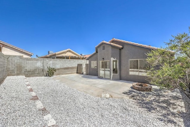 6456 First View Ave, Las Vegas, NV 89142 - back of property featuring stucco siding, a fire pit, a fenced backyard, a patio area, and a tile roof
