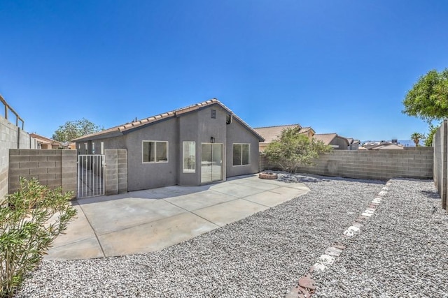 6456 First View Ave, Las Vegas, NV 89142 - rear view of house with a fenced backyard, stucco siding, a gate, a patio, and a tile roof