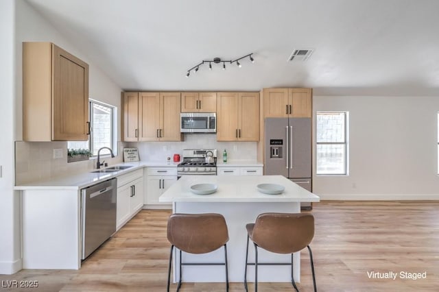 6456 First View Ave, Las Vegas, NV 89142 - kitchen with stainless steel appliances, light wood-type flooring, a center island, and light countertops