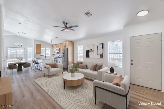 6456 First View Ave, Las Vegas, NV 89142 - living room with a chandelier, light wood-style flooring, ceiling fan, and vaulted ceiling
