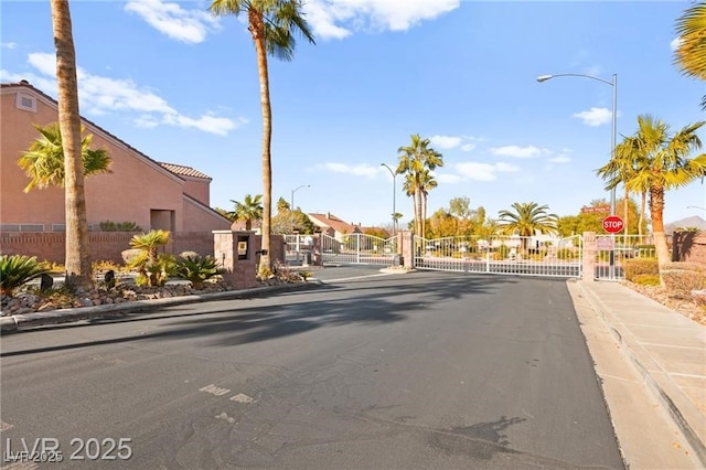 262 Cielito Lindo St, Henderson, NV 89012 - view of asphalt street featuring a gate, sidewalks, traffic signs, curbs, and street lights