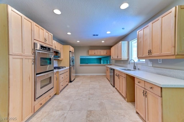8729 Pesaro Dr, Las Vegas, NV 89117 - kitchen featuring stainless steel appliances, light brown cabinets, recessed lighting, and light countertops