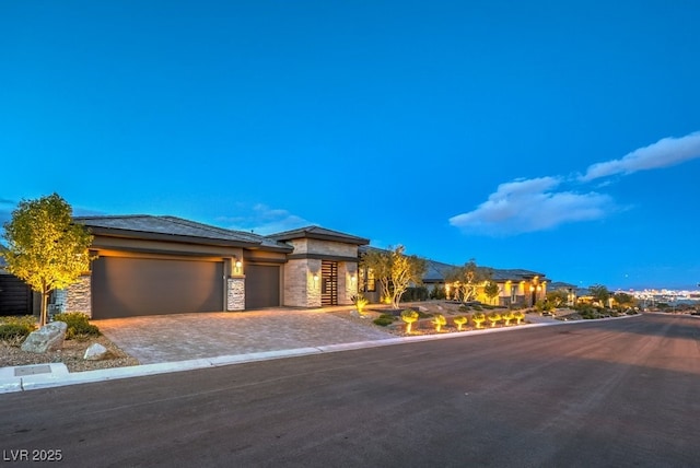 12544 Claymore Highland Ave, Las Vegas, NV 89138 - prairie-style house with an attached garage, decorative driveway, and stone siding