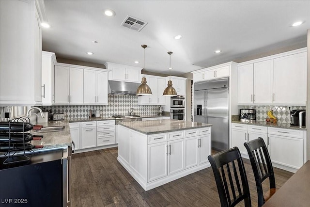 364 Trentino Alto St, Henderson, NV 89012 - kitchen with stainless steel appliances, tasteful backsplash, a kitchen island, under cabinet range hood, and dark wood finished floors