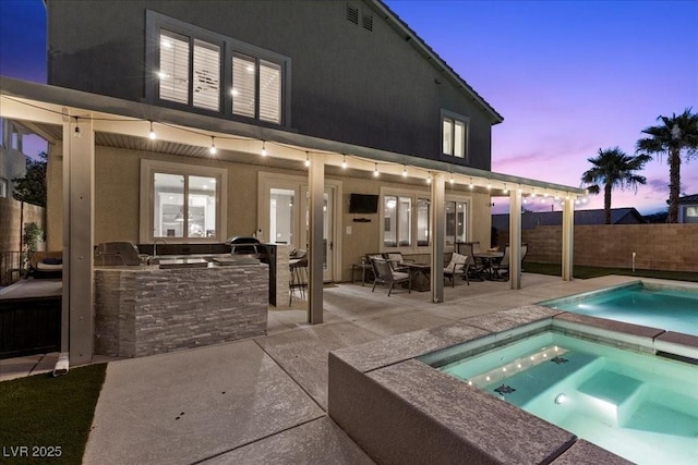 364 Trentino Alto St, Henderson, NV 89012 - rear view of house featuring an outdoor kitchen, an in-ground hot tub, a patio area, a fenced backyard, and stucco siding