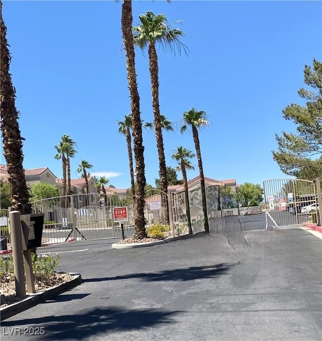 9470 Peace Way Unit 212, Las Vegas, NV 89147 - view of asphalt road with a gate, a gated entry, and curbs