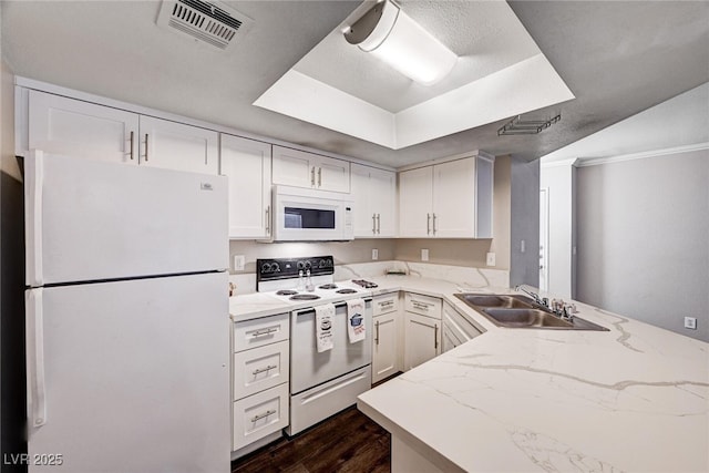 8600 W Charleston Blvd Unit 1059, Las Vegas, NV 89117 - kitchen featuring white appliances, dark wood-style floors, a peninsula, light stone counters, and white cabinets