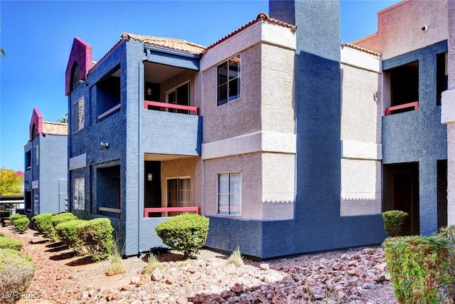 8600 W Charleston Blvd Unit 1059, Las Vegas, NV 89117 - view of home's exterior with a balcony, a tile roof, and stucco siding