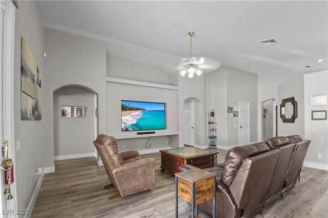 2512 Huber Heights Dr, Las Vegas, NV 89128 - living room with arched walkways, wood finished floors, and a ceiling fan