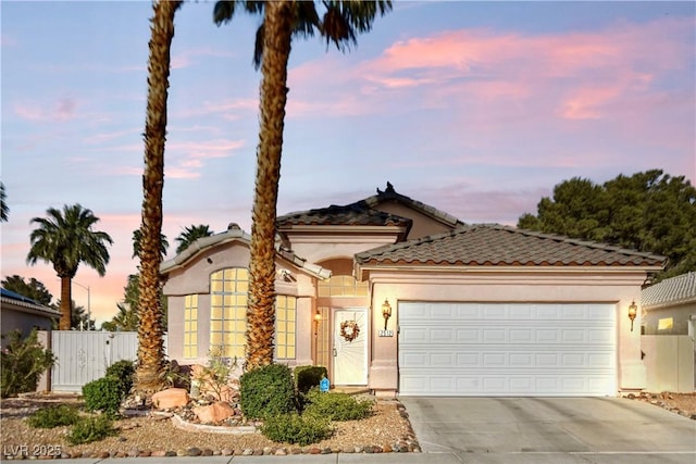 2512 Huber Heights Dr, Las Vegas, NV 89128 - view of front of home featuring concrete driveway, a garage, stucco siding, a tiled roof, and a gate