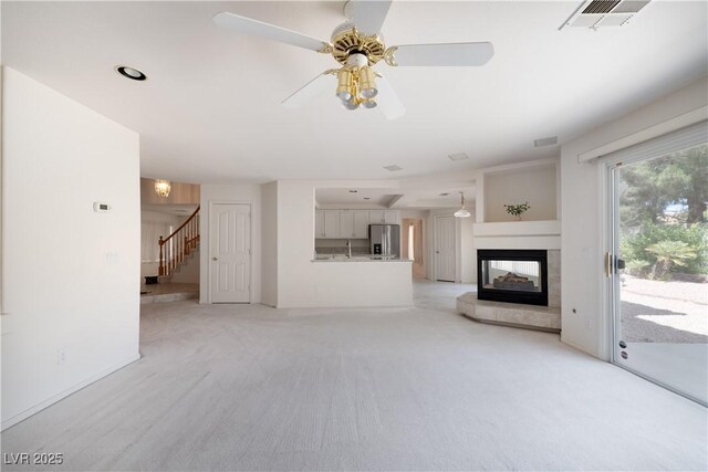 9604 Summer Cypress St, Las Vegas, NV 89123 - unfurnished living room with stairway, a multi sided fireplace, light colored carpet, and ceiling fan