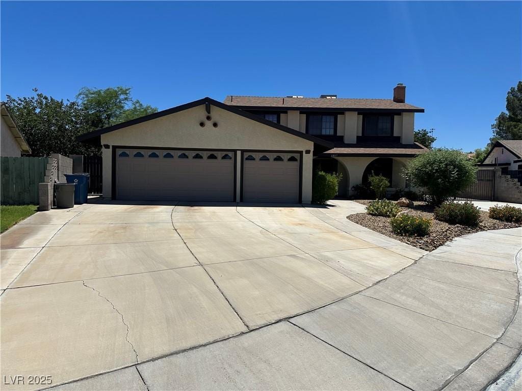 6817 Neepawa Cir, Las Vegas, NV 89108 - traditional-style house with a garage, driveway, stucco siding, and a chimney