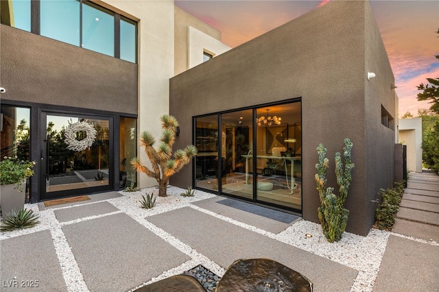 12 Desert Lake Ln, Henderson, NV 89011 - exterior entry at dusk with stucco siding and uncovered parking