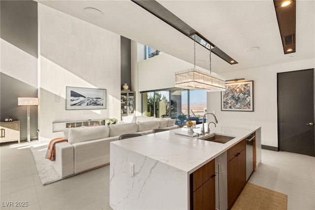 12 Desert Lake Ln, Henderson, NV 89011 - kitchen with modern cabinets, open floor plan, light tile patterned floors, a kitchen island with sink, and a high ceiling