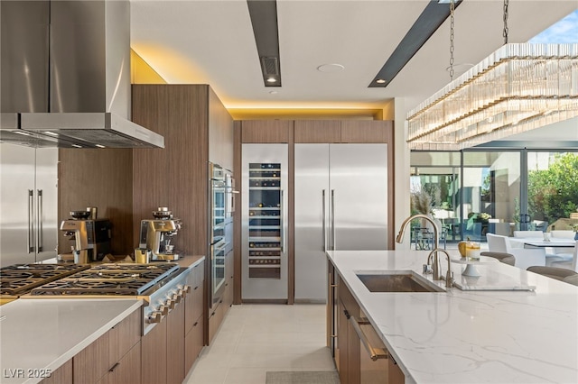 12 Desert Lake Ln, Henderson, NV 89011 - kitchen featuring exhaust hood, appliances with stainless steel finishes, light stone counters, modern cabinets, and brown cabinetry