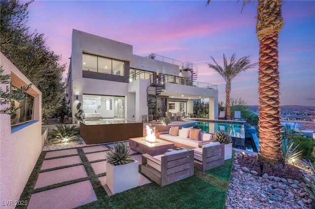 12 Desert Lake Ln, Henderson, NV 89011 - rear view of house featuring a balcony, an outdoor living space with a fire pit, a patio, stucco siding, and an outdoor pool