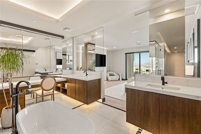 12 Desert Lake Ln, Henderson, NV 89011 - bathroom with two vanities, a freestanding tub, tile patterned floors, recessed lighting, and a shower stall