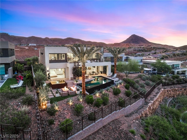 12 Desert Lake Ln, Henderson, NV 89011 - back of house at dusk featuring a mountain view, stucco siding, a patio, outdoor lounge area, and a balcony