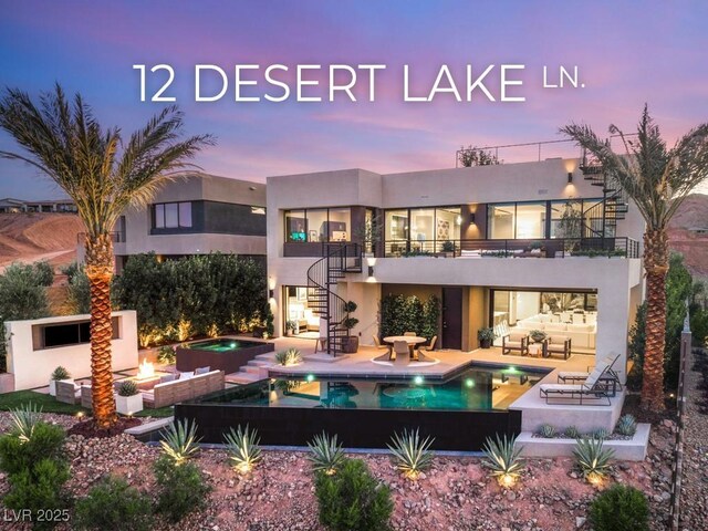12 Desert Lake Ln, Henderson, NV 89011 - back of house featuring a balcony, stairway, an outdoor living space with a fire pit, and stucco siding