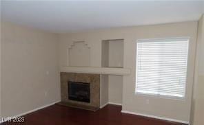 1851 Hillpointe Rd Unit 1711, Henderson, NV 89074 - unfurnished living room featuring a tile fireplace and baseboards
