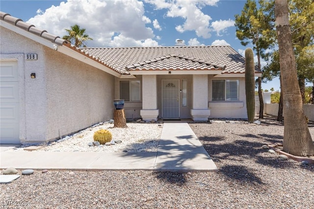 998 Hunters Run Dr, Henderson, NV 89002 - view of front facade with a tile roof, stucco siding, and an attached garage