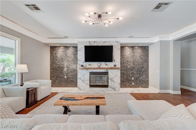 5913 Audria Falls Ave, Las Vegas, NV 89131 - living area with a chandelier, a fireplace, wood finished floors, and crown molding