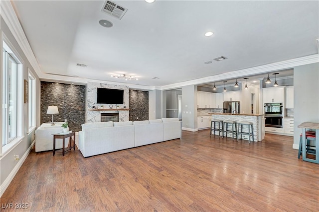 5913 Audria Falls Ave, Las Vegas, NV 89131 - living area with ornamental molding, wine cooler, a large fireplace, wood finished floors, and recessed lighting