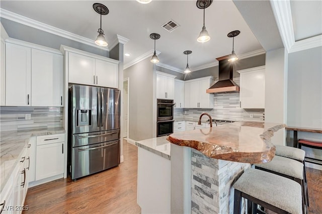 5913 Audria Falls Ave, Las Vegas, NV 89131 - kitchen featuring appliances with stainless steel finishes, wall chimney exhaust hood, light stone countertops, tasteful backsplash, and a kitchen bar