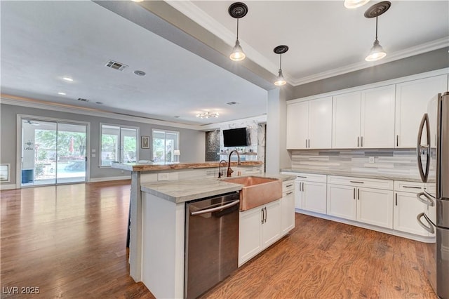 5913 Audria Falls Ave, Las Vegas, NV 89131 - kitchen with appliances with stainless steel finishes, open floor plan, ornamental molding, light wood-style flooring, and decorative backsplash