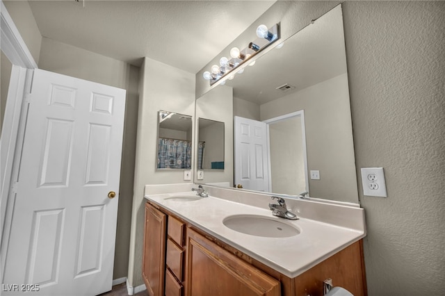 6377 W Haleh Ave, Las Vegas, NV 89141 - full bathroom with double vanity and a textured wall