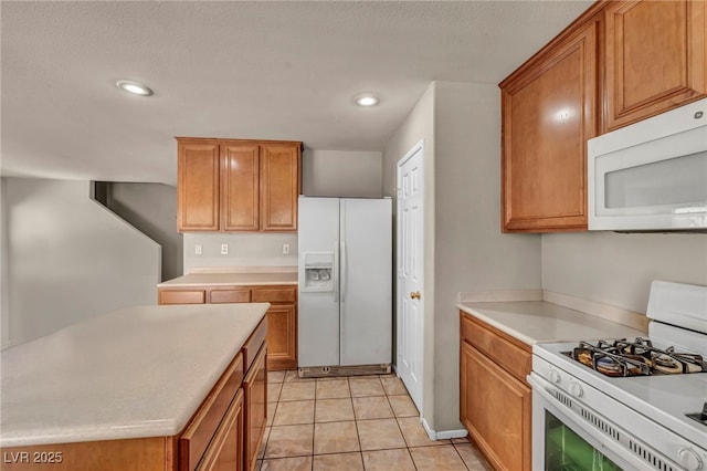 6377 W Haleh Ave, Las Vegas, NV 89141 - kitchen featuring white appliances, light countertops, recessed lighting, brown cabinetry, and a textured ceiling
