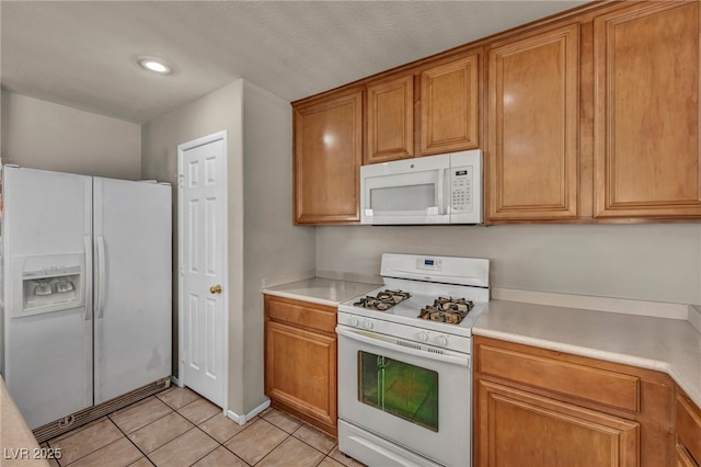 6377 W Haleh Ave, Las Vegas, NV 89141 - kitchen featuring white appliances, brown cabinetry, light tile patterned floors, light countertops, and recessed lighting