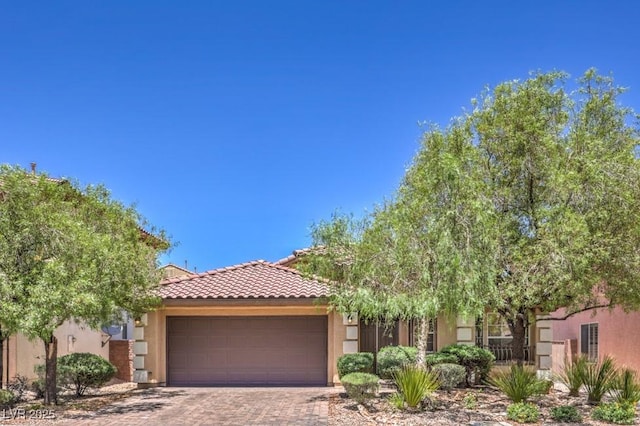7998 Base Camp Ave, Las Vegas, NV 89178 - view of front of home with an attached garage, a tiled roof, stucco siding, and decorative driveway